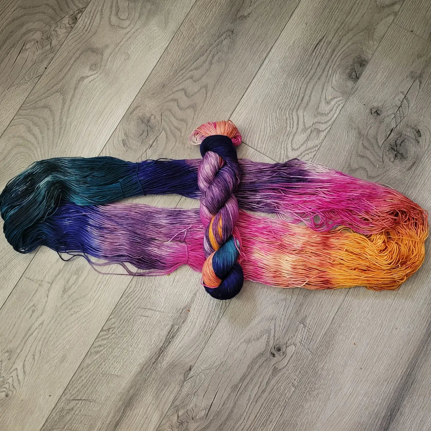 Multicolored skein of yarn on a wooden floor